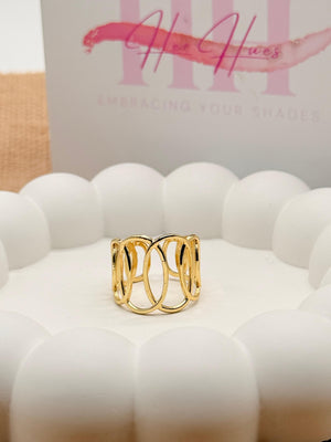 Gold ring on a white surface with 'Her Hue' branding in the background